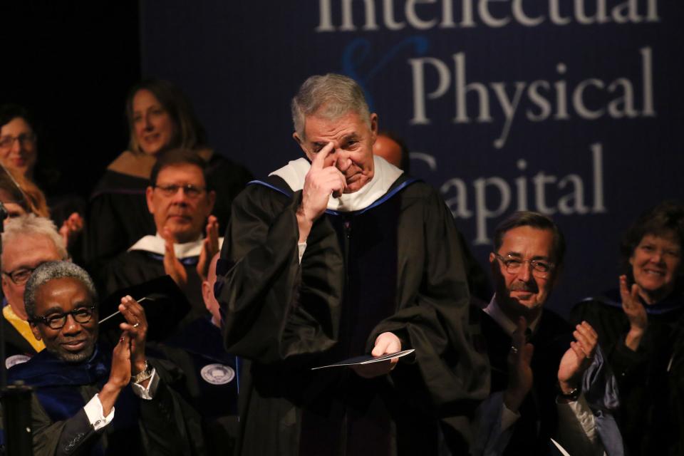 Former University of Delaware president David Roselle, gestures back to the audience after he was acknowledge during the inauguration of its 28th president, Dennis Assanis, on Wednesday.