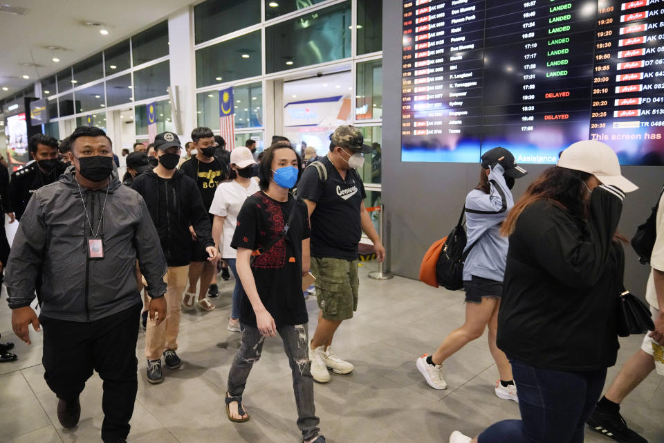 Malaysian youths rescued from human traffickers in Cambodia arrive at the Kuala Lumpur Airport Terminal in Sepang, Malaysia, Friday, Sept. 9, 2022. Foreign Minister Saifuddin Abdullah urged Malaysians to be wary of offers of lucrative jobs and free holidays, as he brought back the two dozen youths. (AP Photo/Vincent Thian)