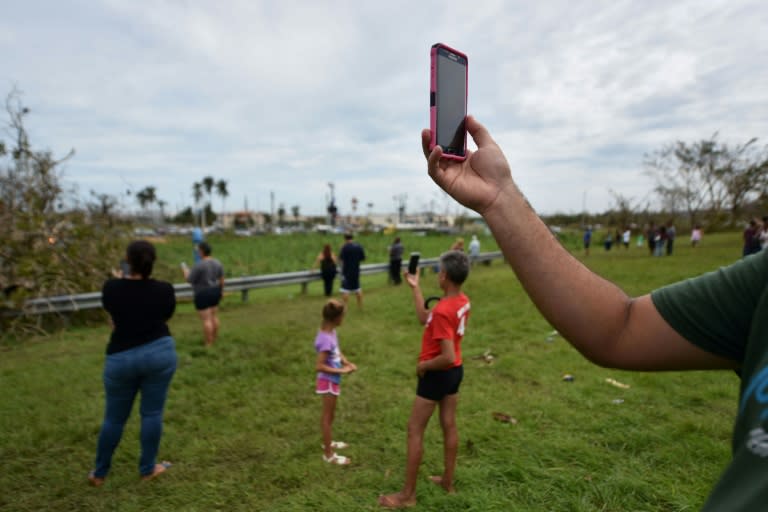 People try to get a cellphone signal in Dorado, north of San Juan, Puerto Rico