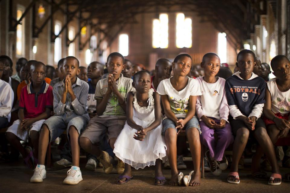 Rwandan children listen and pray during a Sunday morning service at the Saint-Famille Catholic church, the scene of many killings during the 1994 genocide, in the capital Kigali, Rwanda Sunday, April 6, 2014. Rwanda will commemorate on Monday the 20-year anniversary of the genocide when ethnic Hutu extremists killed neighbors, friends and family during a three-month rampage of violence aimed at ethnic Tutsis and some moderate Hutus, leaving a death toll that Rwanda puts at 1,000,050. (AP Photo/Ben Curtis)