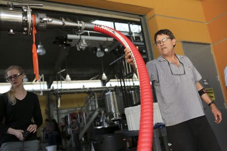 Winemaker and facility manager Chick Brennemen checks a hose at the University of California Davis during a wine grape harvest in Davis, California August 21, 2014. REUTERS/Robert Galbraith