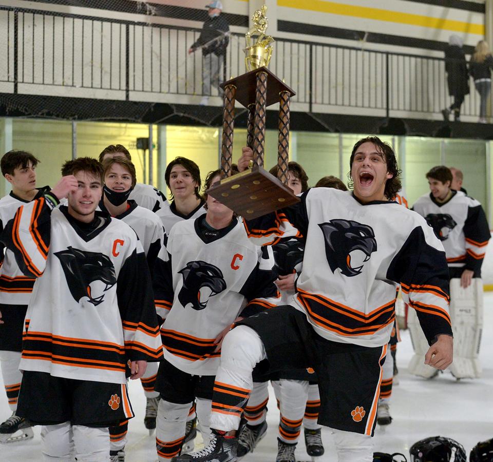 Marlborough High School hockey senior Jeremy LaCroix lifts the trophy towards the fans after defeating Algonquin Regional High School, 5-2,  to win the Daily News Cup tournament at the New England Sports Center, Dec. 29, 2021.