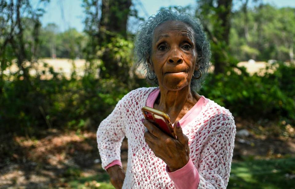 Josephine Wright, 98, stands in her yard while speaking with her granddaughter on speakerphone on May 9, 2023 about their experience as a family with the development company building a residential community surrounding their family land on Jonesville Road on Hilton Head Island.