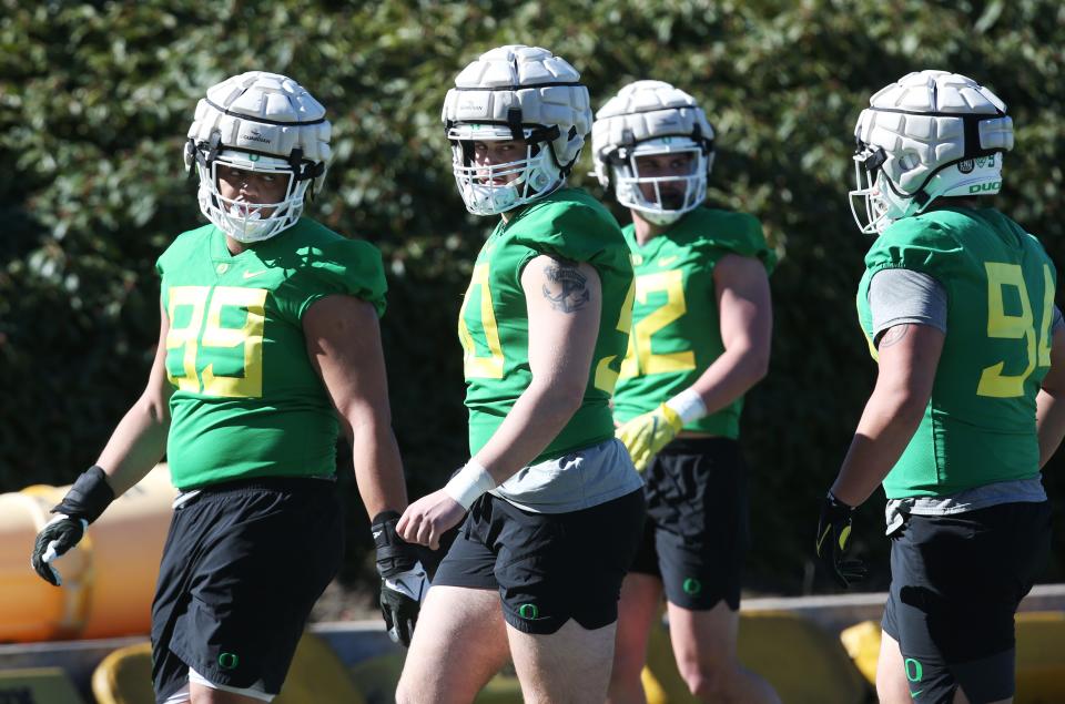 Oregon's Jake Shipley, center, joins the defense during practice for 2022.