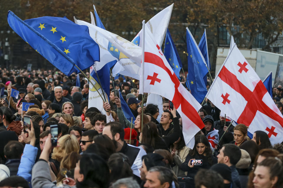 Georgians wave EU and national flags as they gather to celebrate Georgia's EU candidacy at Liberty Square in Tbilisi, Georgia, on Friday, Dec. 15, 2023. Several thousand people attend a march in support of Georgia's EU candidacy. European Union flags waved across Georgia Friday after the European Council took a step forward along the long road towards granting Georgia and Moldova as EU membership. (AP Photo/Zurab Tsertsvadze)