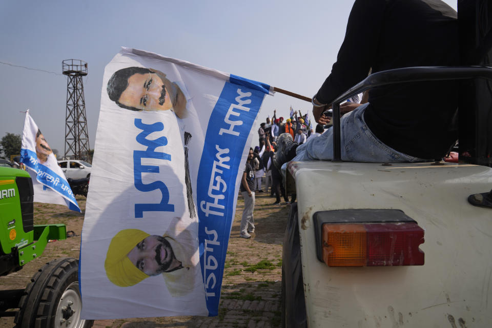 Supporters of Aam Aadmi Party's candidate Harbhajan Singh from the Jandiala constituency brandish the party symbol flag, a broom to sweep out corruption, during a door to door election campaign on the outskirts of Amritsar, in Indian state of Punjab, Tuesday, Feb. 15, 2022. India's Punjab state will cast ballots on Sunday that will reflect whether Indian Prime Minister Narendra Modi's ruling Bharatiya Janata Party has been able to neutralize the resentment of Sikh farmers by repealing the contentious farm laws that led to year-long protests. (AP Photo/Manish Swarup)