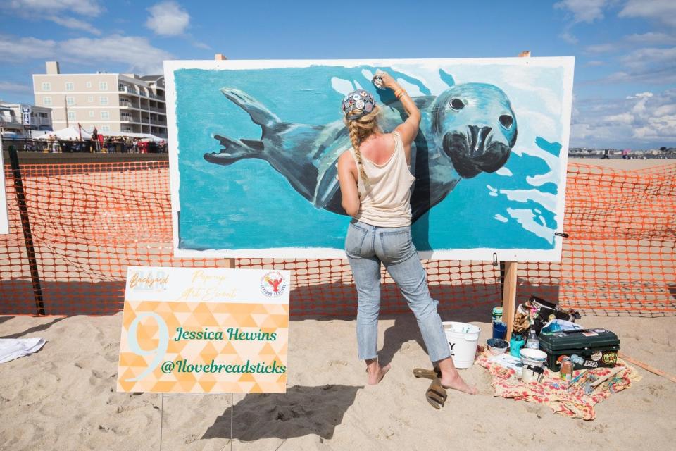 Jessica Hewins with her seal painting at last year's Hampton Beach Pop-Up Art Event on the sand.