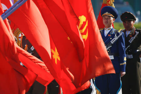 North Korean soldiers stand behind flags before an opening ceremony for a newly constructed residential complex in Ryomyong street in Pyongyang, North Korea April 13, 2017. REUTERS/Damir Sagolj