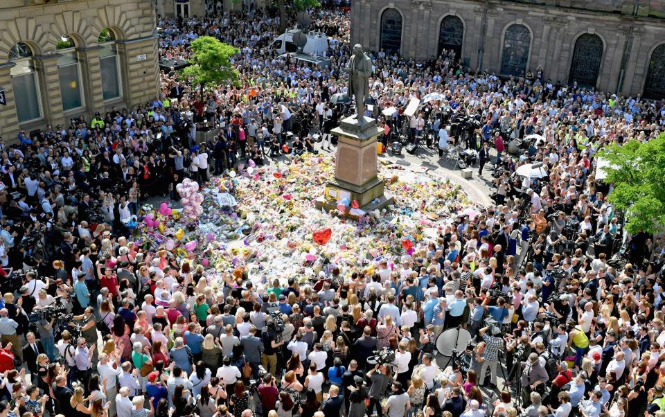 Members of the public observe a national minute's silence in remembrance of all those who lost their lives in the Manchester Arena attack, on May 25, 2017 in Manchester