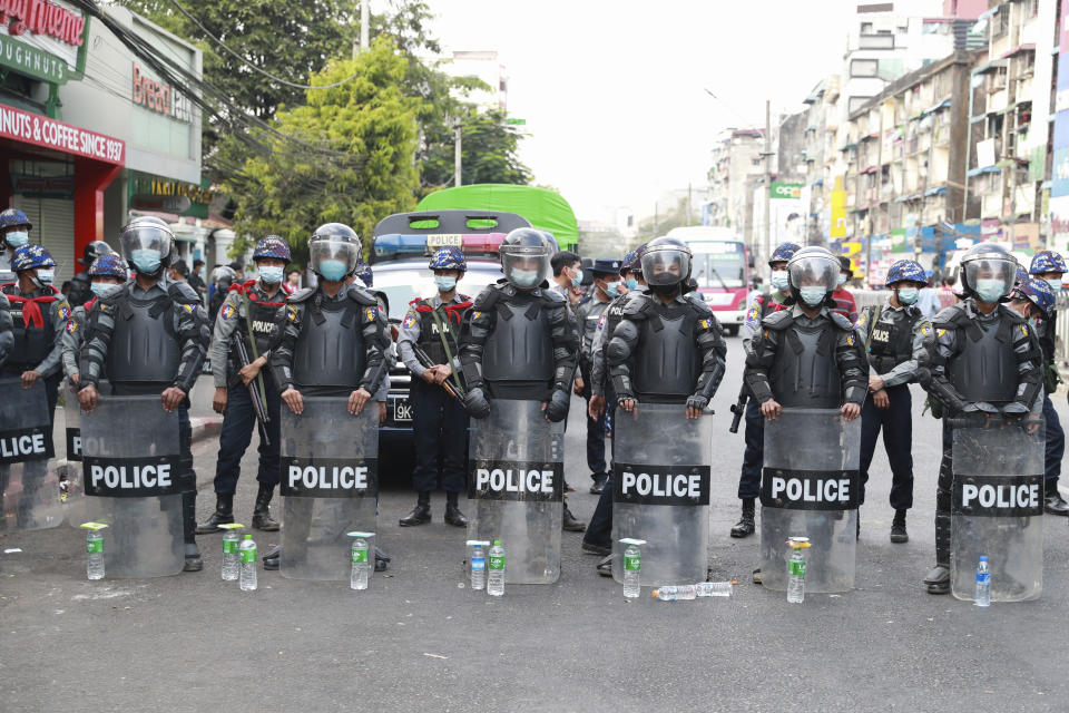 Police in riot gear stand guard while blocking a road to prevent protesters from marching forward in Yangon, Myanmar, on Feb. 6, 2021. Protests in Myanmar against the military coup that removed Aung San Suu Kyi’s government from power have grown in recent days despite official efforts to make organizing them difficult or even illegal. (AP Photo)