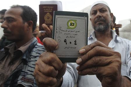 Foreign workers displays his passport as he waits outside a labour office, after missing a deadline to correct his visa status, in Riyadh November 4, 2013. REUTERS/Faisal Al Nasser