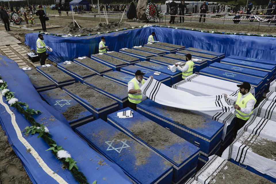 Volunteers perform the final rites before burying the remains of Holocaust victims at a cemetery just outside Brest, Belarus, Wednesday, May 22, 2019. Remains of more than 1,000 Holocaust victims were laid to rest on Wednesday in a Belarusian city on the border with Poland after a mass grave was discovered on a building site earlier this year. (Uladz Hrydzin, Radio Free Europe/Radio Liberty via AP)