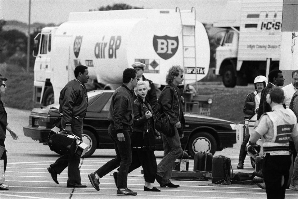 American singer and actress Madonna (centre, facing camera) arrives at the Leeds Bradford airport, on the way to her first British concert at Roundhay Park, in Leeds.