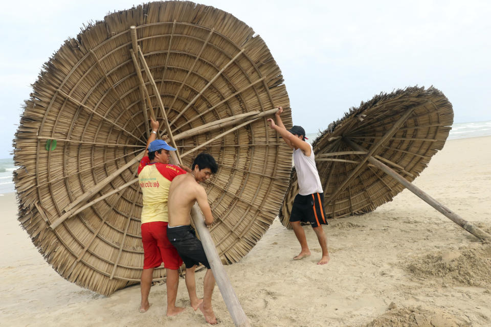 People remove beach cabanas ahead of Typhoon Molave in Danang, Vietnam on Monday, Oct. 26, 2020. National agency forecasts the typhoon to hit Vietnam on Wednesday morning in the central region where 1.3 people could face evacuation. (Tran Le Lam/VNA via AP)