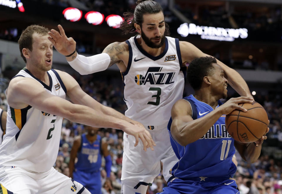 Utah’s Joe Ingles and Ricky Rubio swarm Mavs guard Yogi Ferrell on Thursday night. (AP)