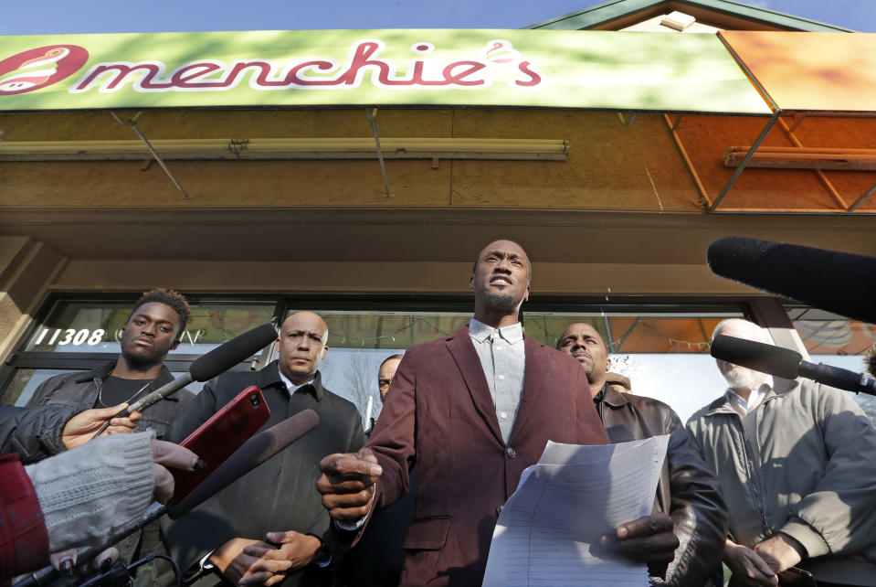 Byron Ragland addresses reporters in front of a frozen-yogurt shop Tuesday, Nov. 20, 2018, in Kirkland, Wash. The police department there has apologized for an incident in which officers helped the owner of the Menchie's shop expel Ragland, an African-American man, from the business because employees said they felt uncomfortable. The Seattle Times reported that the shop's owner called police on Nov. 7 about Ragland, who works as a court-appointed special advocate, who was in the shop supervising a court-sanctioned outing between a mother and her son. (AP Photo/Elaine Thompson)