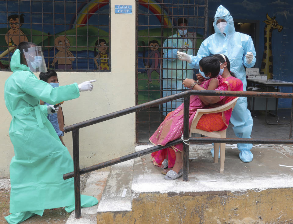 A health worker takes a nasal swab sample of a child to test for COVID-19 in Hyderabad, India, Saturday, Aug. 22, 2020. India has the third-highest caseload after the United States and Brazil, and the fourth-highest death toll in the world. (AP Photo/Mahesh Kumar A.)