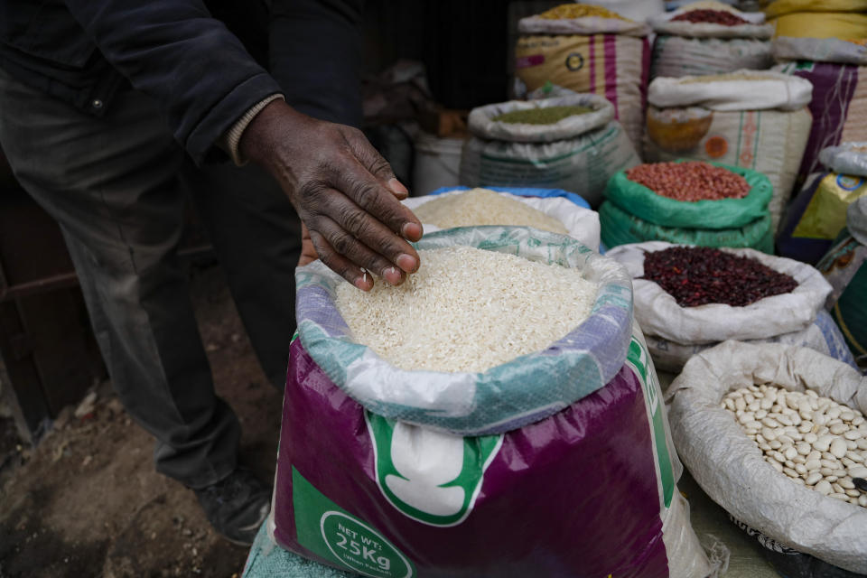 Vendor Francis Ndege measures rice at his stall at the Toi Market in Nairobi, Kenya, on Wednesday, Aug. 9, 2023. Countries worldwide are scrambling to secure rice after a partial ban on exports by India cut global supplies by roughly a fifth. Now, Ndege isn’t sure if his customers in Africa’s largest slum can afford to keep buying rice from him. (AP Photo/Brian Inganga)
