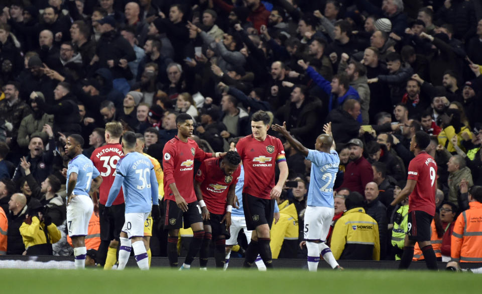 Players react to items thrown by Manchester City fans during the English Premier League soccer match between Manchester City and Manchester United at Etihad stadium in Manchester, England, Saturday, Dec. 7, 2019. (AP Photo/Rui Vieira)