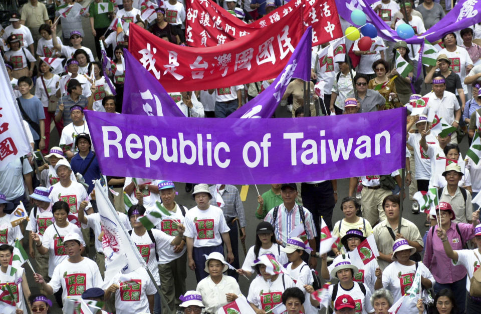 FILE - In this May 11, 2002, file photo, pro-Taiwan supporters carry banners during a march of about 8,000 people asking the government to change the island's official name from the "Republic of China" to "Taiwan," in Taipei, Taiwan. The residents of this self-governing island, with its vibrant and well-established democracy, seem as much inclined as ever to resist China’s demands despite rising political, economic and military threats from Beijing. (AP Photo/Jerome Favre, File)