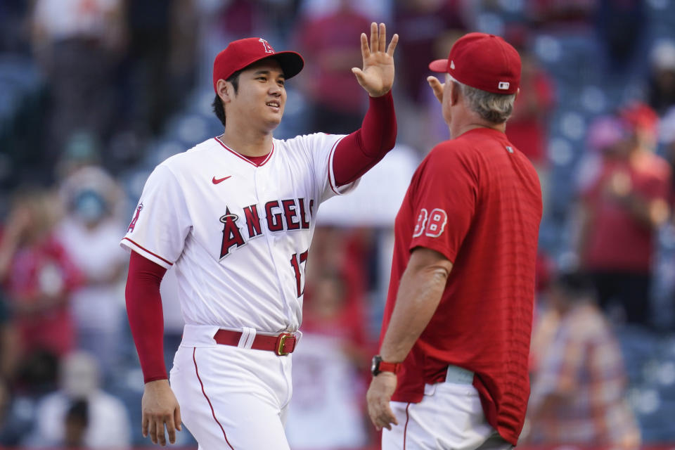 Los Angeles Angels designated hitter Shohei Ohtani (17) high-fives interim manager Phil Nevin (88) after am 8-3 win over the Texas Rangers in a baseball game in Anaheim, Calif., Sunday, Oct. 2, 2022. (AP Photo/Ashley Landis)