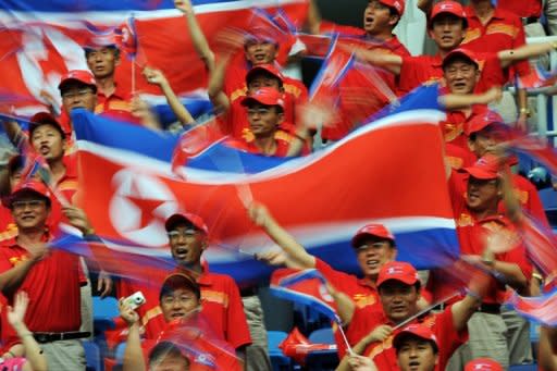 North Korean fans cheer their team before the start of the women's 1st round football match against Germany at the 2008 Beijing Olympic Games