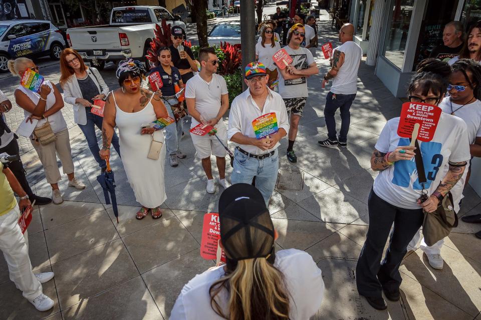 People gather on Clematis Street to walk to the city commission meeting at city hall in downtown West Palm Beach.