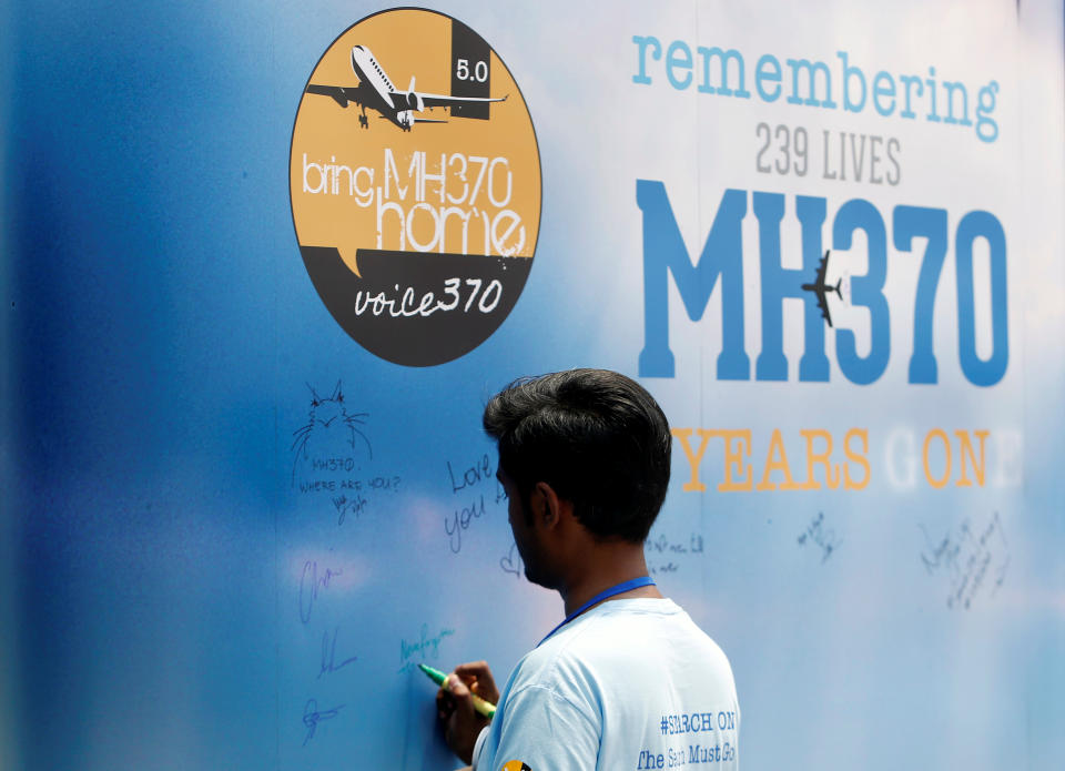 A man writes on a message board for passengers, onboard the missing Malaysia Airlines Flight MH370, during its fifth annual remembrance event in Kuala Lumpur, Malaysia March 3, 2019. REUTERS/Lai Seng Sin