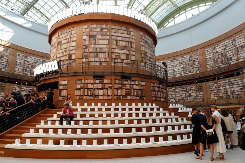 <p>A central circular pillar housed thousands of books with guest seated on the stairs to view the show.</p>