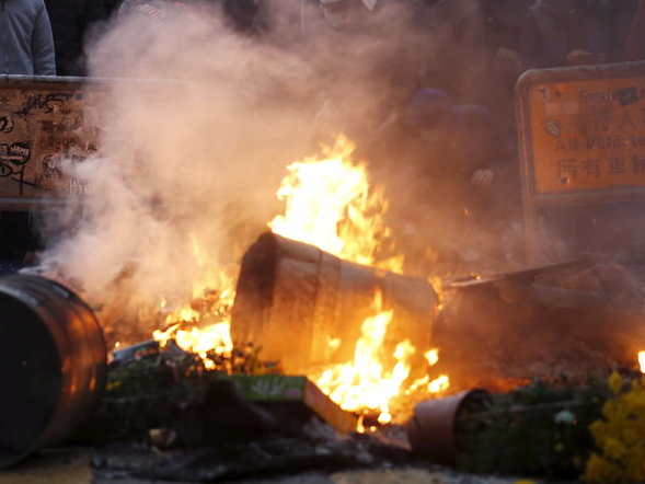 Protesters look on behind a fire set by them at a junction at Mongkok district in Hong Kong, China February 9, 2016.</p>
<p>  REUTERS/Bobby Yip 