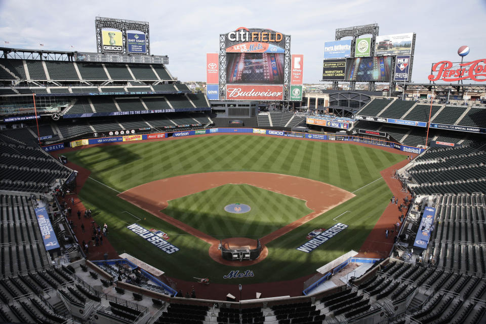 FILE - In this Oct. 29, 2015, file photo, members of the media and grounds crew work on the field at Citi Field in New York, the day before Game 3 of the World Series between the Mets and the Kansas City Royals at the stadium. Baseball Commissioner Rob Manfred says talks have ended over the proposed sale of a controlling share of the Mets from the families of Fred Wilpon and Saul Katz to hedge fund manager Steven Cohen. (AP Photo/Peter Morgan, File)