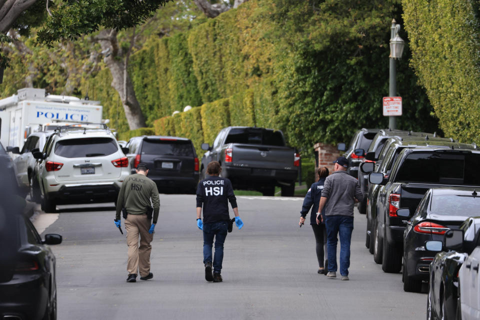 Homeland Security investigative agents are seen outside the home of American producer and musician Sean 