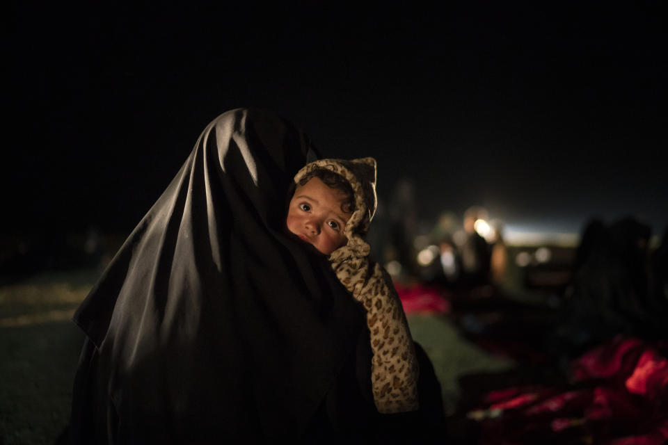 FILE - In this Feb. 25, 2019 file photo, a woman carries her baby at a screening center run by U.S.-backed Syrian Democratic Forces after being evacuated out of the last territory held by Islamic State militants, outside Baghouz, Syria. Hundreds of thousands of Syrians face continued displacement each coming year if the conflict continues and economic conditions further deteriorate, the Norwegian Refugee Council, a prominent humanitarian organization said Monday, March 8, 2021. The Syrian conflict, which marks 10 years later this month, has resulted in the largest displacement crisis since World War II, the council said. (AP Photo/Felipe Dana, File)