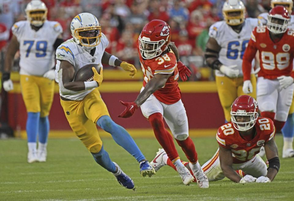 Chargers receiver Joshua Palmer (5) tries to elude Chiefs cornerback L'Jarius Sneed (38) after making a reception.