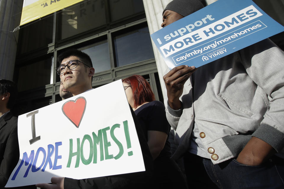 FILE - In this Jan. 7, 2020, file photo, men hold up signs at a rally outside of City Hall in Oakland, Calif., in support of more housing. California lawmakers have failed to pass the most ambitious proposal yet to combat a growing housing crisis in the nation's most populous state, voting down legislation Wednesday, Jan. 29, that would have overridden local zoning laws to let developers to build small apartment buildings in neighborhoods reserved for single-family homes. (AP Photo/Jeff Chiu, File)