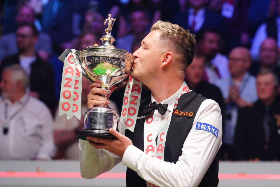 Wilson celebrates with the trophy after winning the world snooker title (PA Wire)
