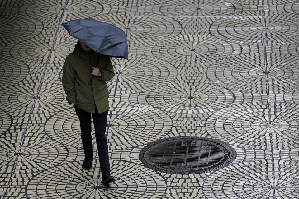 A pedestrian carries an umbrella while walking in San Francisco, Tuesday, March 14, 2023. (AP Photo/Jeff Chiu)