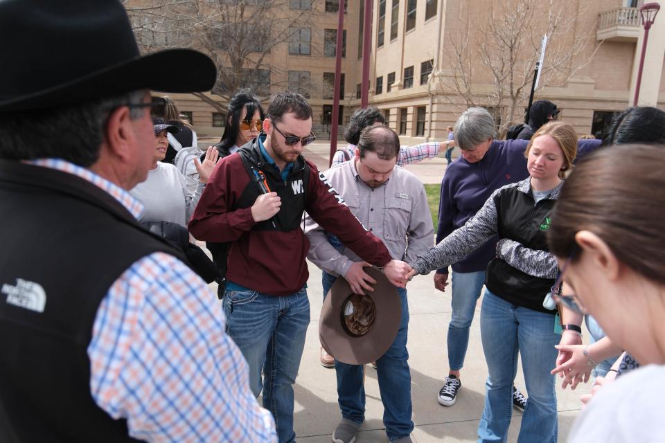 A group holds hands in prayer Thursday in support of WT President Walter Wendler and his letter canceling a drag show on campus in Canyon.