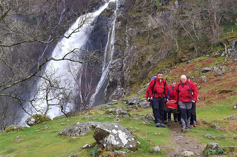 An injured woman being stretchered from Aber Falls (Rhaeadr Fawr) by members of the Ogwen Valley Mountain Rescue Organisation. Unable to attend a show at Llandudno's Venue Cymru that evening, she and her partner donated their tickets to the team as a mark of gratitude. Just off picture, a man was on one knee proposing to his girlfriend