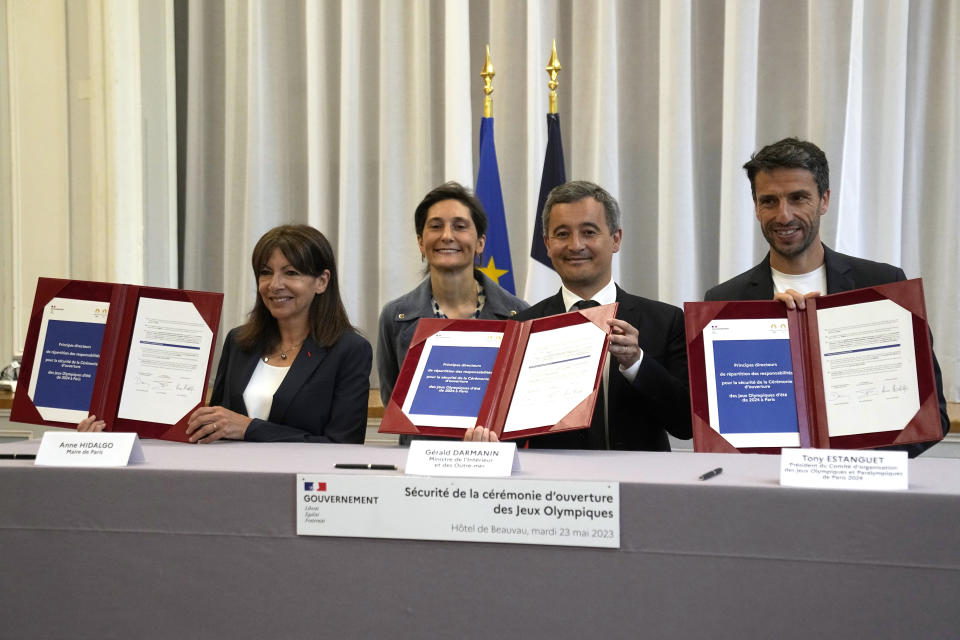 From the left, Paris mayor Anne Hidalgo, Sports Minister Amelie Oudea-Castera, Interior Minister Gerald Darmanin and Head of Paris 2024 Olympics Tony Estanguet show documents during a meeting on the Paris 2024 Olympics opening ceremony, Tuesday, May 23, 2023 in Paris. French security experts have expressed misgivings about size and complexity of the security operation that will be needed to safeguard Paris' ambitions for the unprecedented opening gala along the River Seine. (AP Photo/Michel Euler)