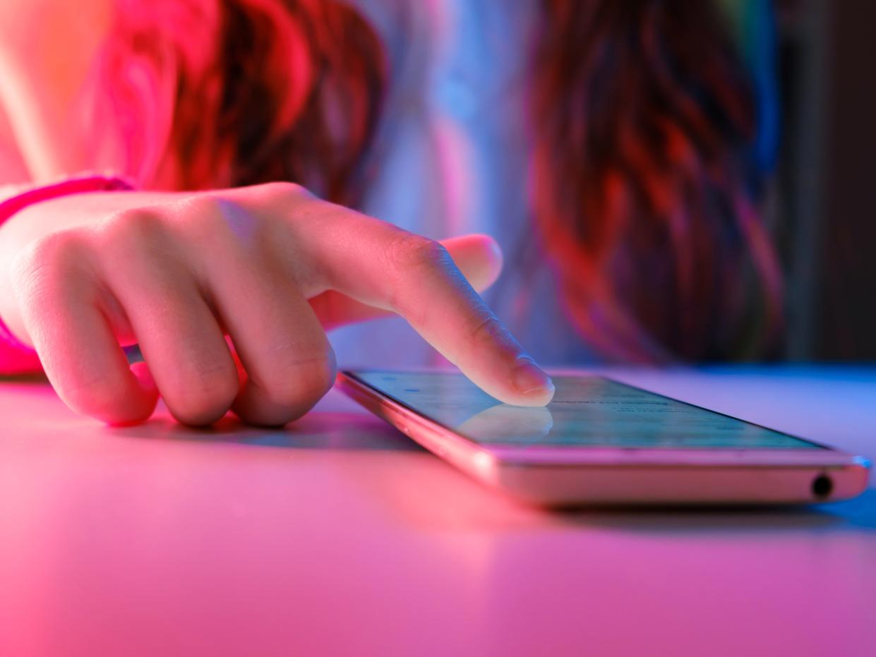 A stock image of someone scrolling through a phone.