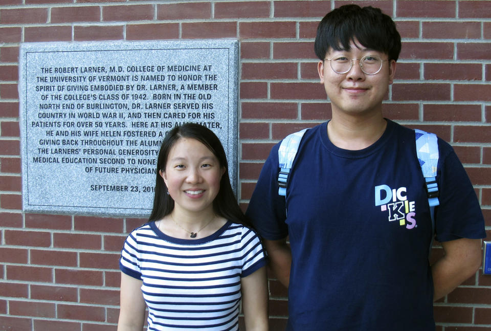 In this photo Aug. 16, 2019, photo, Chinese graduate students Zhaojin Li, left, and Pengfei Liu, pose in front of the entrance to the Robert Larner College of Medicine at the University of Vermont in Burlington, Vt. Some higher education officials are concerned by a drop in the number of international students coming to the United States, especially from China. Li and Liu say that some of their relatives were concerned for their safety in coming to the United States, but they are too busy with their studies to focus on geopolitical issues. (AP Photo/Wilson Ring)