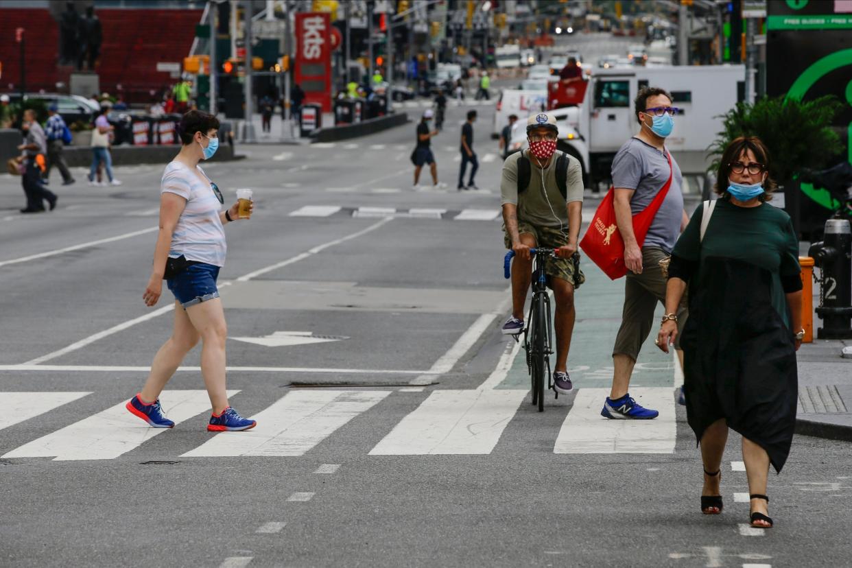 Masked pedestrians walk in Manhattan's Times Square: AP