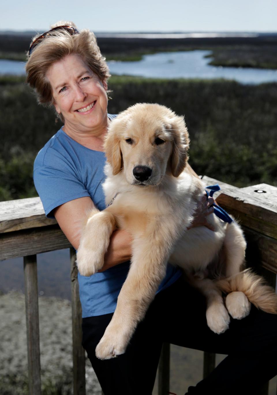 Jacksonville artist Kathy Stark with her dog Talbot on the Round Marsh overview in the Theodore Roosevelt Area of Timucuan Preserve. Stark has created a series of paintings paying homage to the stylized WPA-era National Parks silkscreened posters dating from the 1930s.