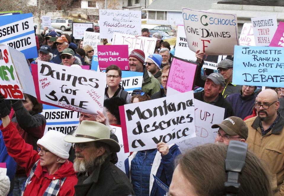 Protesters wave signs as they listen to speakers outside the Montana Capitol in Helena on Tuesday, Feb. 21, 2017. Hundreds of protesters who were upset that U.S. Sen. Steve Daines wasn't planning a town hall this week decided to bring one to him instead outside of the Montana Capitol, where Daines was scheduled to address the state Legislature on Tuesday. (AP Photo/Matt Volz)