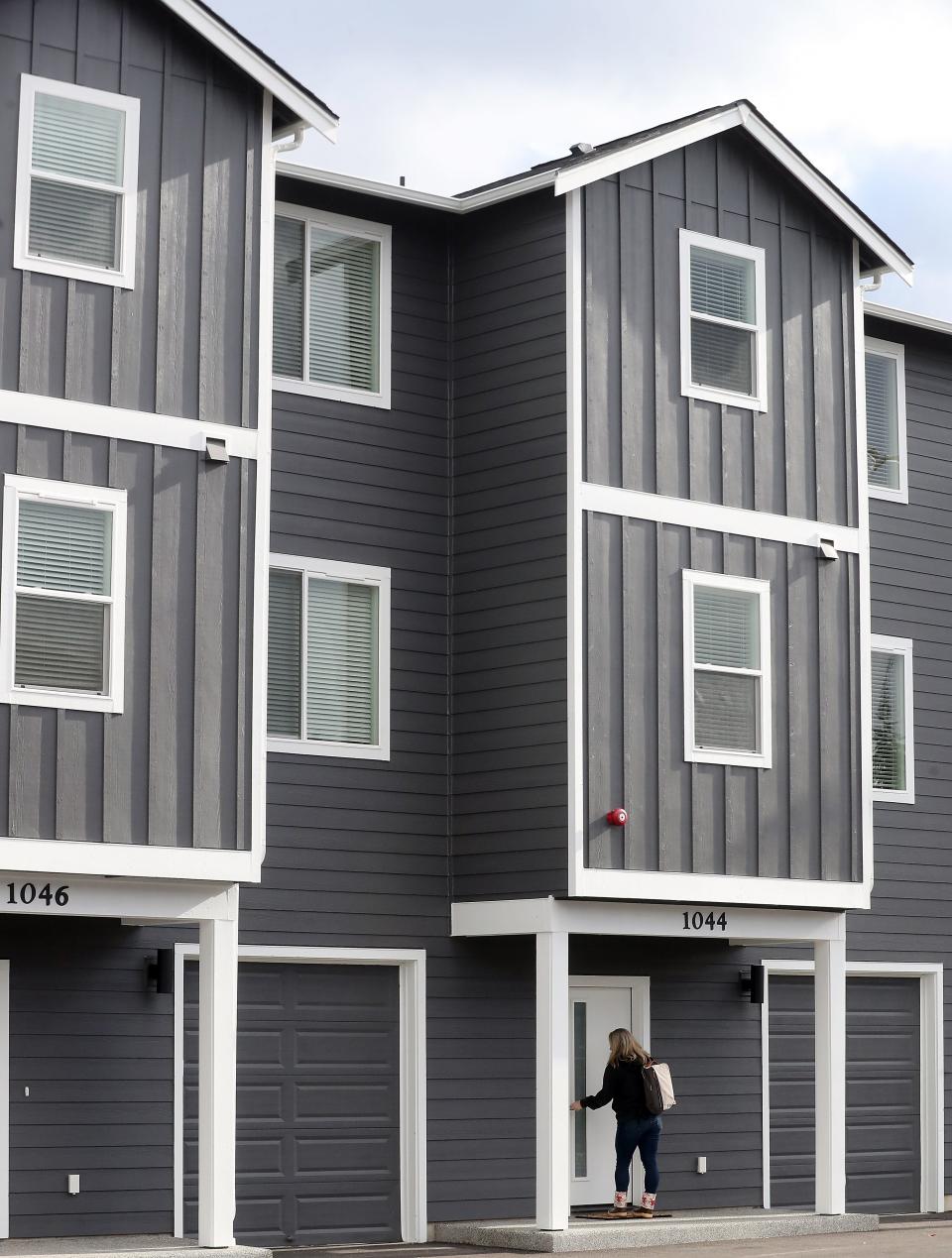 Jennifer Lang, director of marketing at Harbor Custom Development Inc., leaves one of the furnished townhomes at Mills Crossing in Bremerton on Nov. 1.