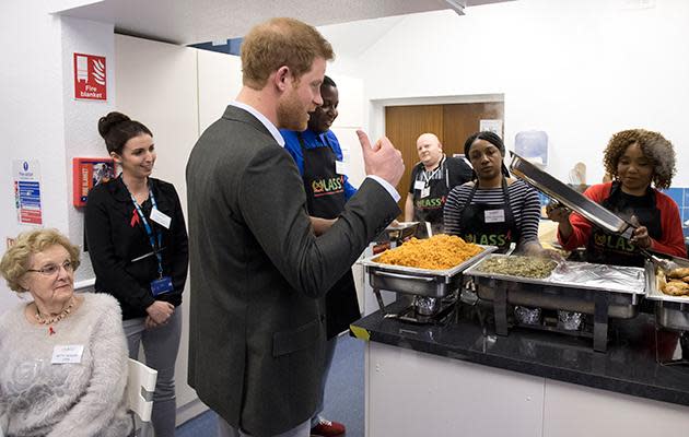 Harry pauses to look at pictures Princess Diana