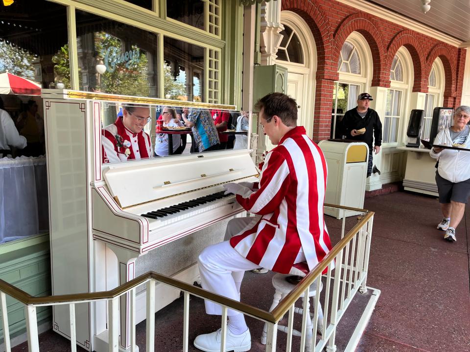 walt disney world piano player playing outside casey's corner at magic kingdom