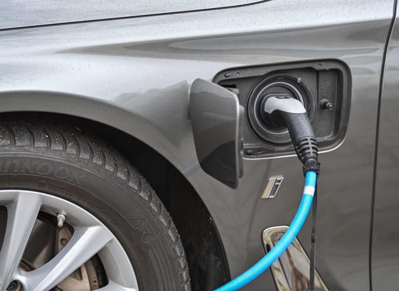 An electric vehicle is being charged at a charging station. The International Energy Agency (IEA) has weighed in on the debate over how to expand the electric car market, saying on Tuesday that growth will depend on their affordability and the availability of charging points. Patrick Pleul/dpa-Zentralbild/ZB