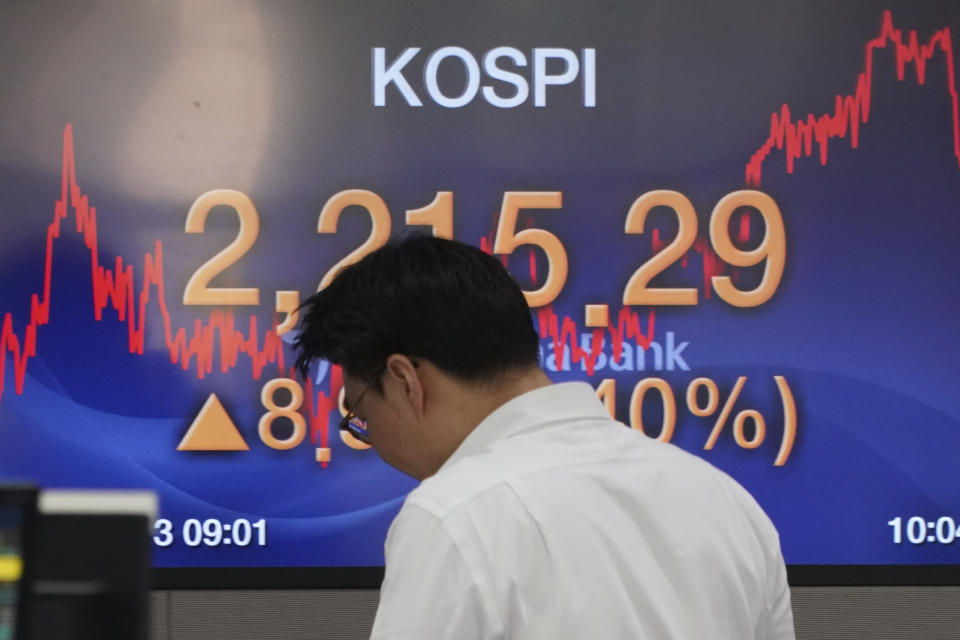 A currency trader walks by the screen showing the Korea Composite Stock Price Index (KOSPI) at the foreign exchange dealing room in Seoul, South Korea, Monday, Jan. 13, 2020. Asian stocks have risen as investors shrug off weaker-than-expected American jobs data and look ahead to the signing of a U.S.-China trade deal. Benchmarks in Shanghai, Hong Kong and Southeast Asia all advanced. (AP Photo/Lee Jin-man)